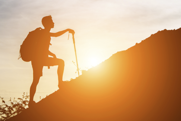 Trailblazer image, a sillouhette picture of a man beginning to climb the ascent of the mountain. 